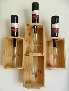 three wine bottles and two glasses in wooden boxes