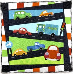 a quilted wall hanging with cars on the road and traffic lights in the background