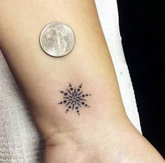 a small snowflake tattoo on the left ankle and right foot, with a quarter penny in the background