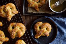 freshly baked pretzels on cooling racks next to a cup of tea and spoon