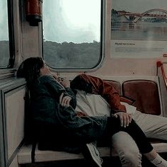 two people sleeping on a train next to each other