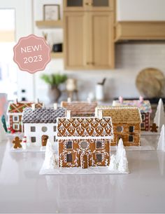 gingerbread houses on a kitchen counter with the words new 2013 above them in pink