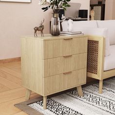 a living room with a white couch and some flowers on top of a wooden cabinet