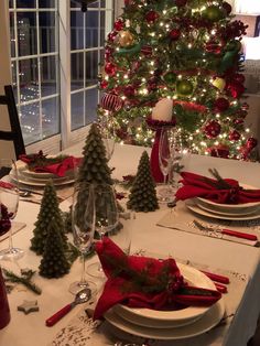 the table is set for christmas dinner with red and green decorations