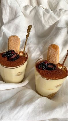 two desserts are sitting on a white cloth