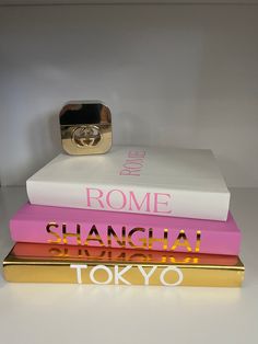 three books stacked on top of each other in front of a gold ring and white background