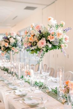 a long table is set with flowers and place settings