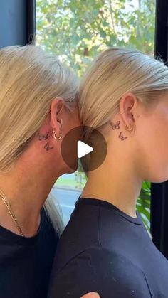 two women with small tattoos on their ears and behind them are the same woman's head