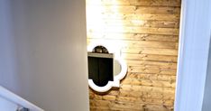 a bathroom with wooden walls and flooring next to a white toilet in the corner