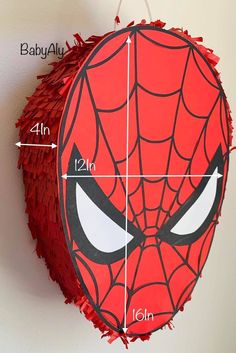 a spiderman pinata hanging on the wall with measurements for it's eyes