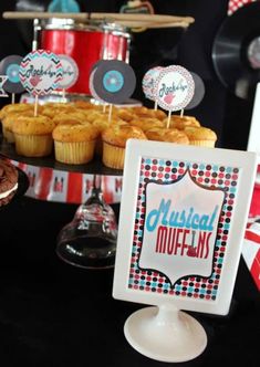 cupcakes and muffins are on display at a music themed birthday party