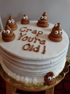 a cake with frosting that says crap you're old on it and five cookies in the shape of eyes