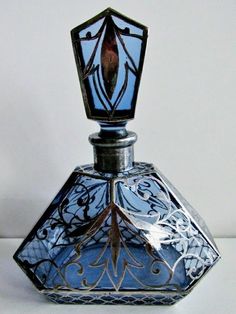 a blue glass bottle sitting on top of a white table next to a black and silver object