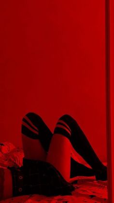 a woman laying on top of a bed next to a red light in a room