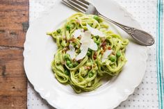 a white plate topped with pasta and peas