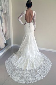 the back of a woman's wedding dress, with her hands on her hips