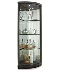 a curved glass display case with bottles and vases on it's sides, against a white background