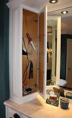 a bathroom with a sink, mirror and hair dryer on the counter in front of it