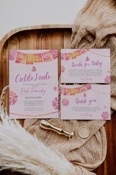 pink and gold wedding stationery on a wooden tray