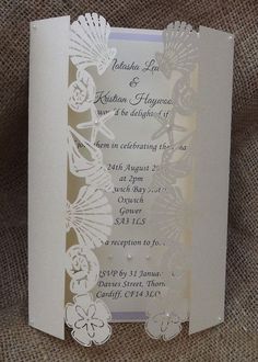 a wedding card with an intricate design on the front and back, sitting on a burlap background