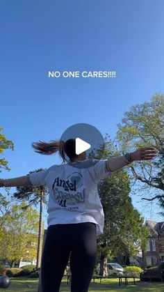 a woman in white shirt and black leggings on skateboard with trees in background