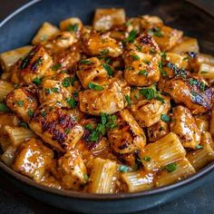 a bowl filled with pasta and chicken covered in sauce