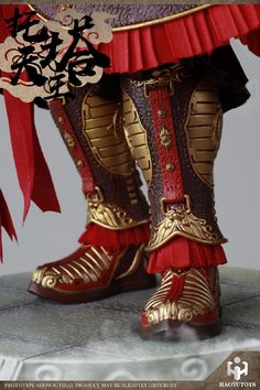 a close up of a person's boots with red and gold decorations on them