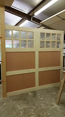 an unfinished garage with wood paneling and windows on the wall, in front of a workbench