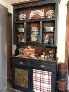 an old fashioned hutch is decorated with pumpkins and other fall decorating items