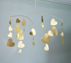 a wind chime with hearts hanging from it's sides in a blue room