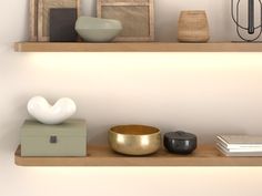 two shelves with vases, books and other items on top of them in front of a white wall