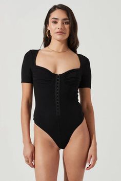 a woman wearing a black bodysuit with buttons