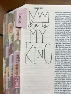 an open bible with the word he is my king written on it and colored stickers