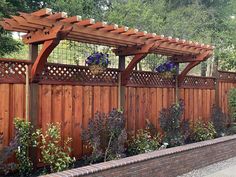 a wooden fence with some plants growing on the top and bottom, along side it