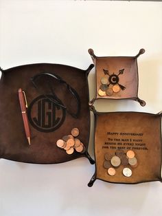 three leather pouches filled with coins and personalized writing on the inside, along with a pen