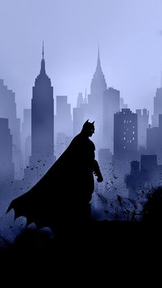 the silhouette of a batman standing in front of a cityscape with skyscrapers