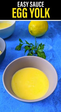 an egg yolk in a white bowl next to lemons and parsley