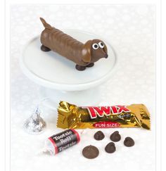 a chocolate dog on a plate next to some candy