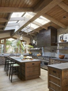 an open kitchen with lots of counter space and skylights above the stove top oven