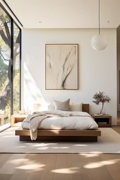 a large bed sitting in the middle of a bedroom next to a tall glass window