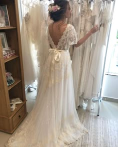 a woman looking at wedding dresses in a store