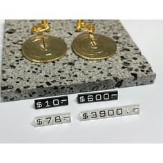 pair of gold earrings with numbers on display