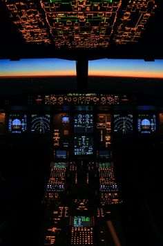 the cockpit of an airplane at night with illuminated instruments and lights on it's windows