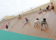 several children are playing on a ramp with skateboards and paddles in front of them