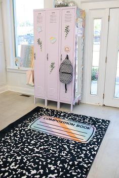 a pink locker sitting in the corner of a room next to a black and white rug