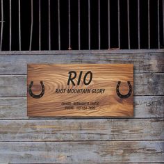 a wooden sign that says rio riot mountain glory with horseshoes on it's sides