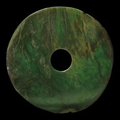 a round green object with a hole in it's center on a black background