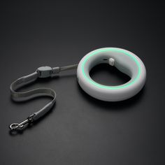 an electronic device with a lanyard attached to it on a black surface next to a keychain