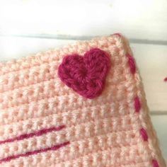 a pink crocheted pillow with a heart on it