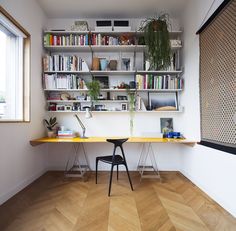 a room with a desk and shelves filled with books